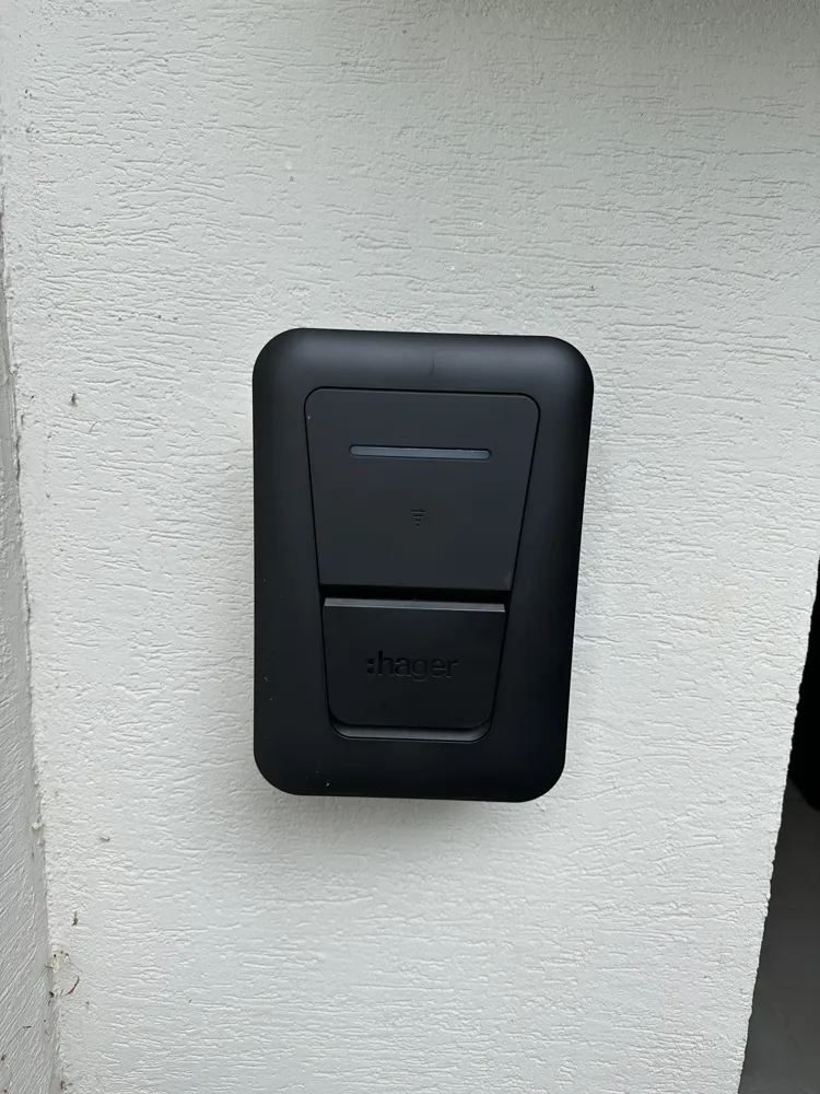 Borne de recharge Hager posée sur le mur d'une maison