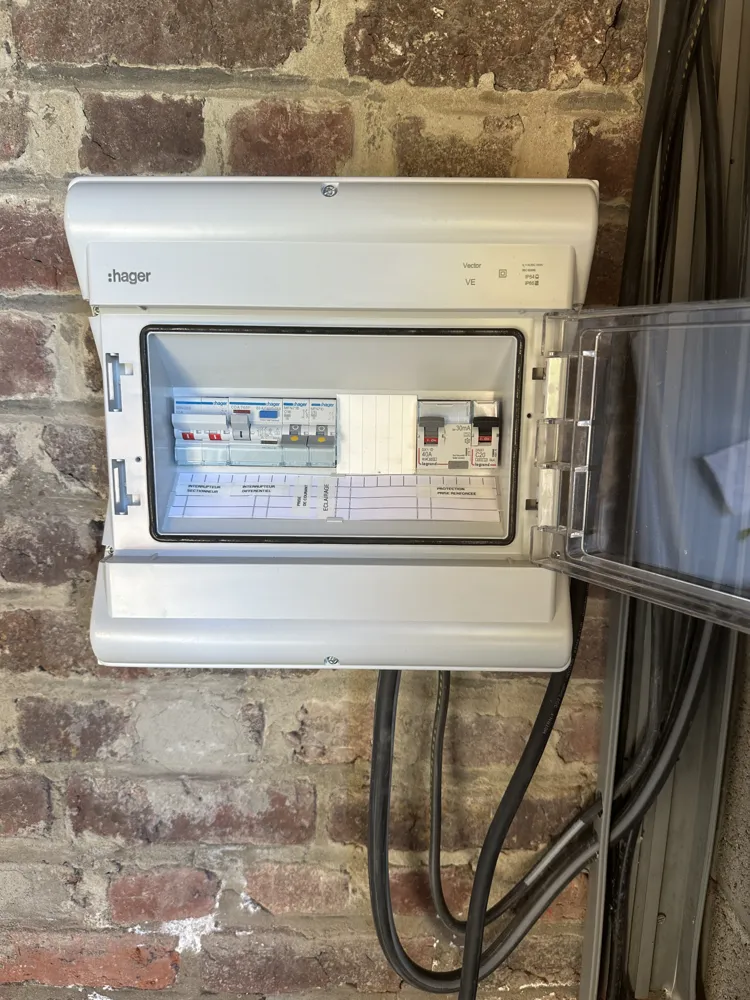 Coffret de protection Hager dédié à une borne de recharge, sur mur en brique