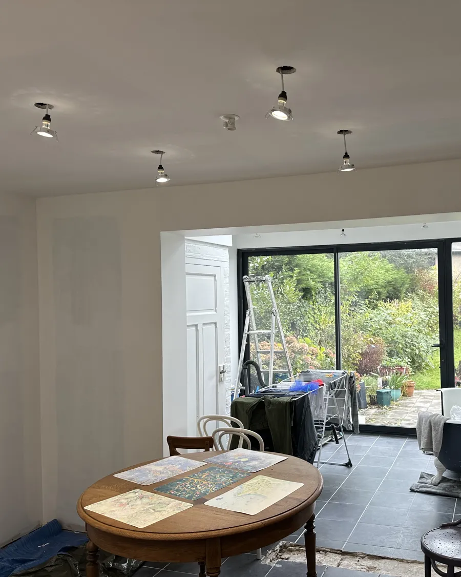 Pose de spots encastrés au plafond d'une pièce de vie en rénovation
