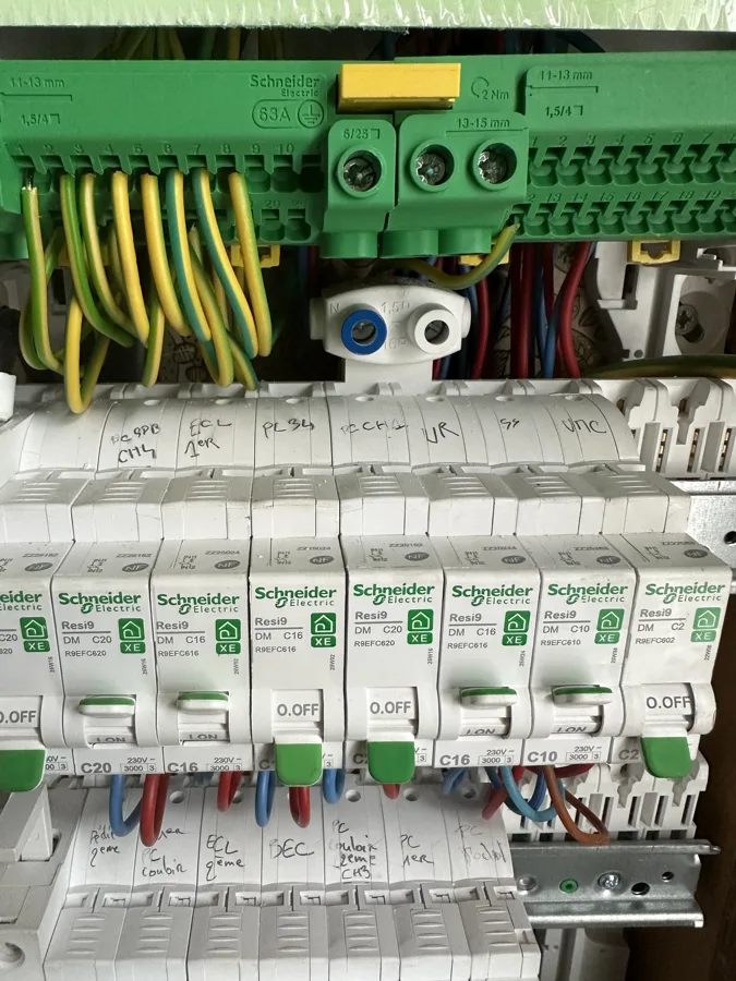 Tableau électrique Schneider Electric Resi9 en cours de câblage, bornier de terre et circuits repérés